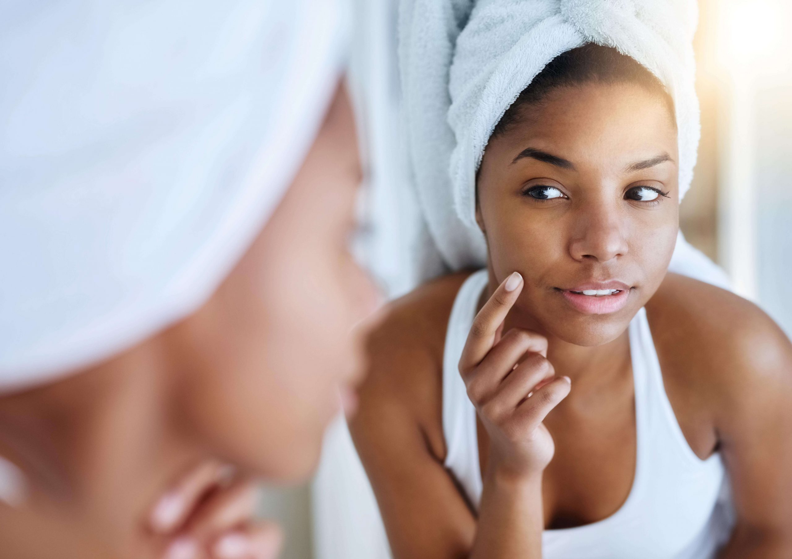 Woman looking at skin in mirror