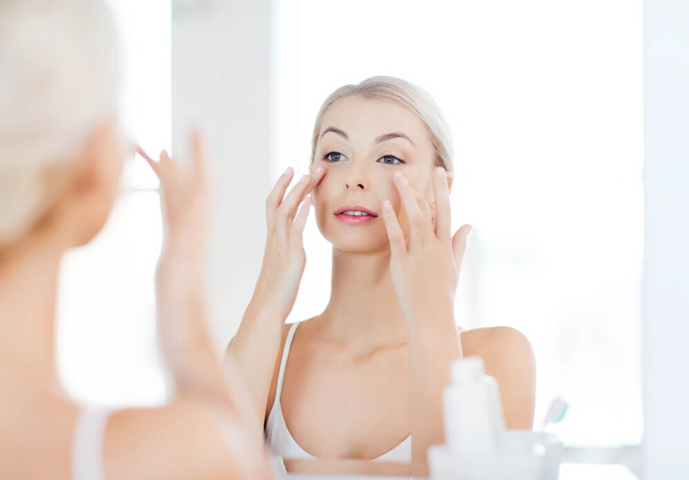 Woman looking at skin in mirror