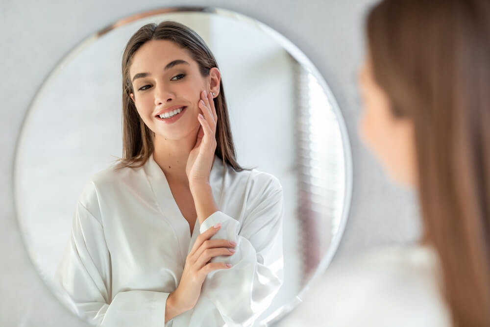 Woman looking at skin in mirror