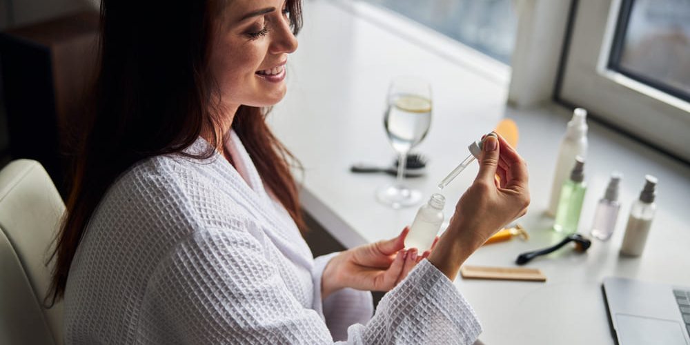 Woman applying antioxidant skincare products