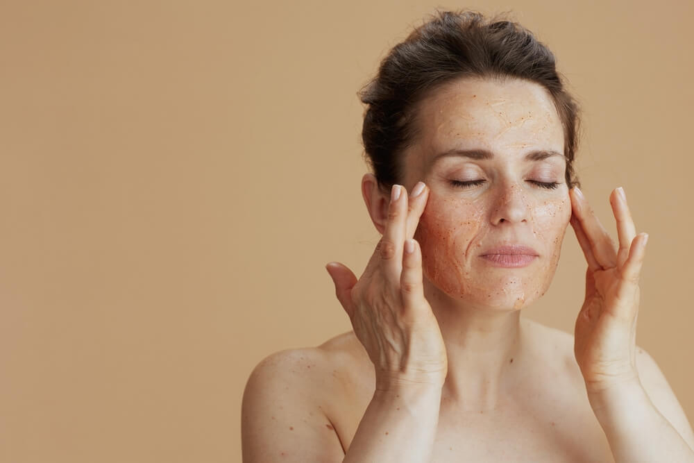 woman exfoliating face