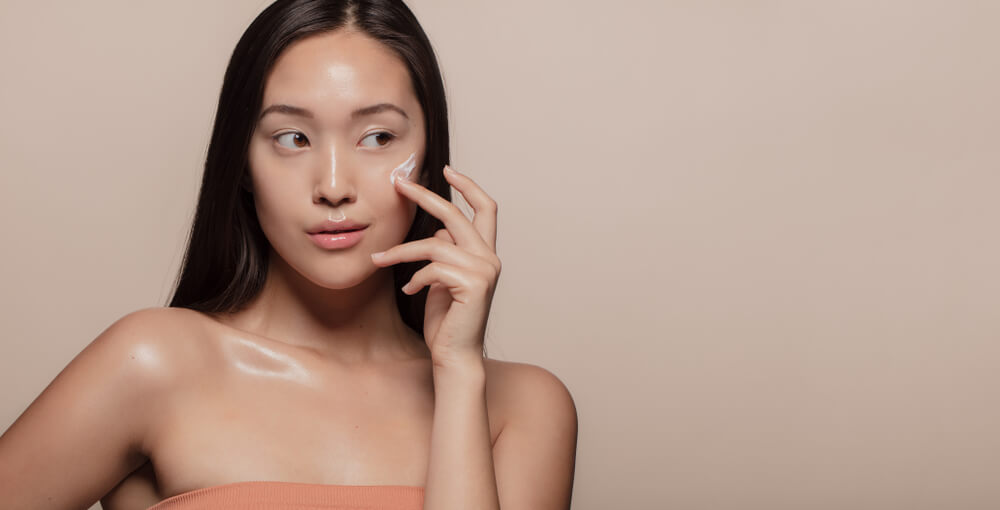 woman applying moisturizer